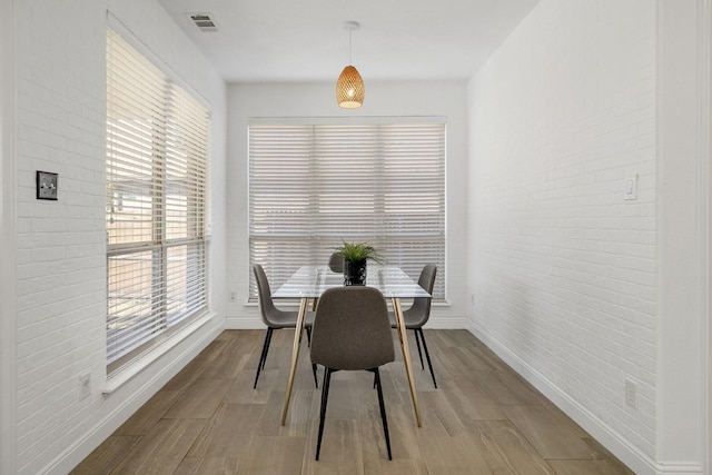 dining area featuring brick wall