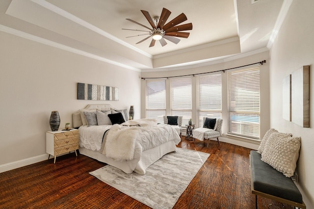 bedroom featuring dark hardwood / wood-style floors, ornamental molding, a raised ceiling, and ceiling fan