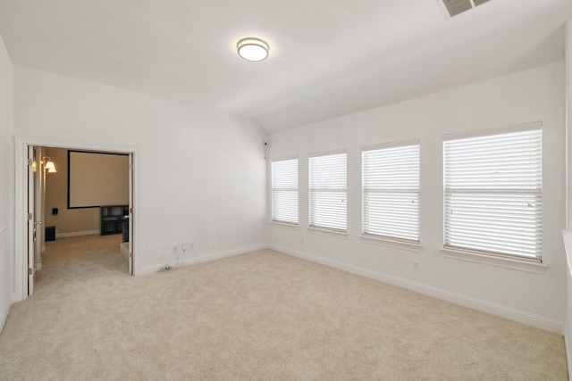 spare room with light carpet and lofted ceiling