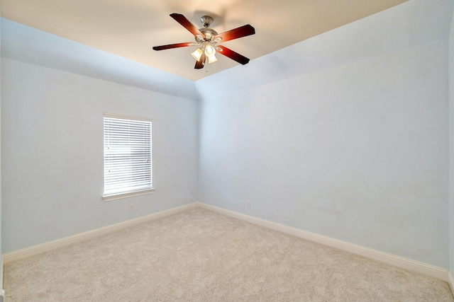 empty room featuring vaulted ceiling, light colored carpet, and ceiling fan