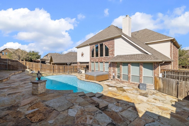 view of swimming pool featuring a hot tub and a patio area