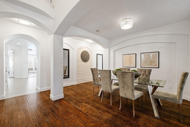 dining space with crown molding and dark hardwood / wood-style floors