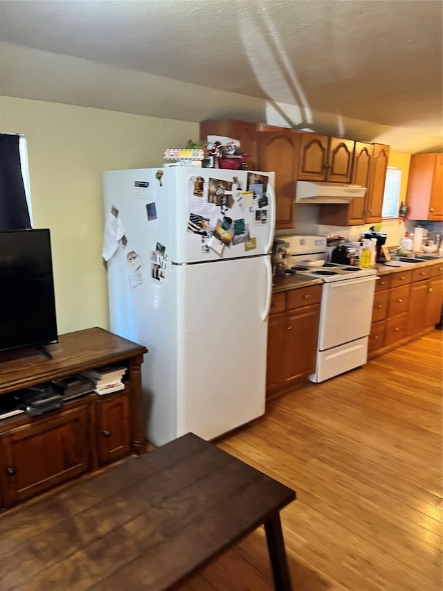 kitchen featuring sink, white appliances, and light hardwood / wood-style flooring