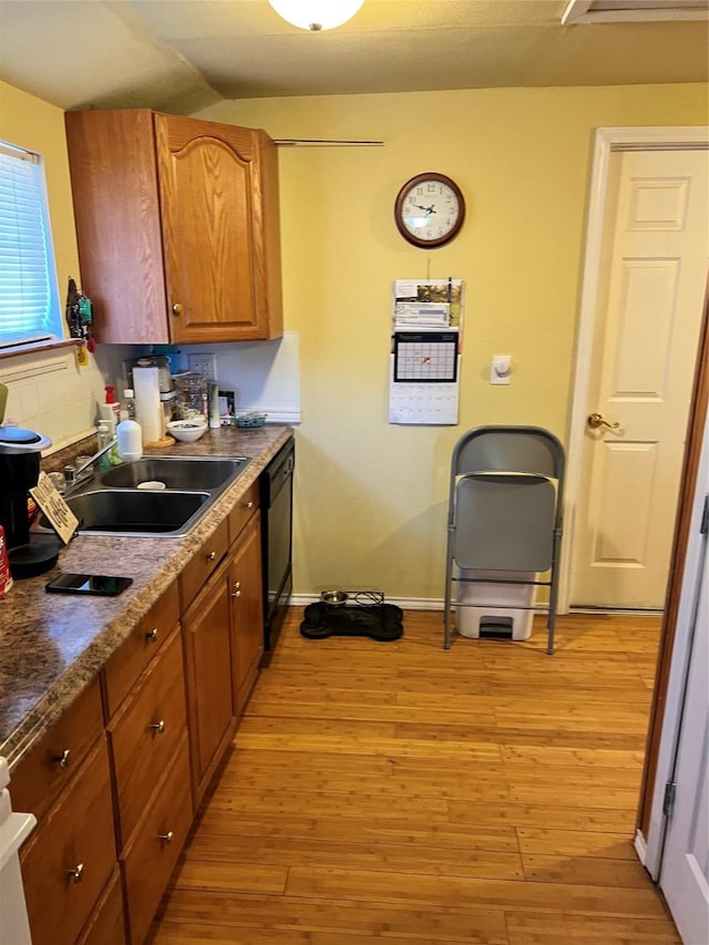 kitchen featuring dishwasher, sink, and light hardwood / wood-style flooring