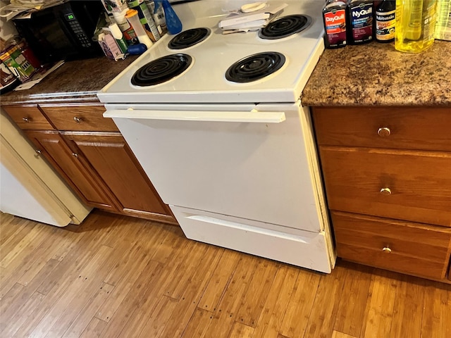 kitchen with white electric range and light hardwood / wood-style floors