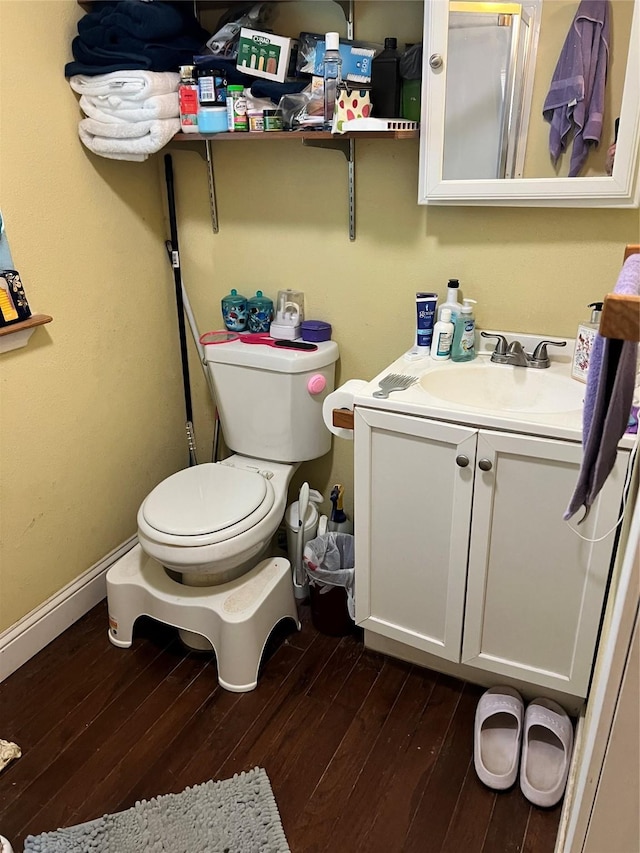 bathroom with hardwood / wood-style flooring, vanity, and toilet