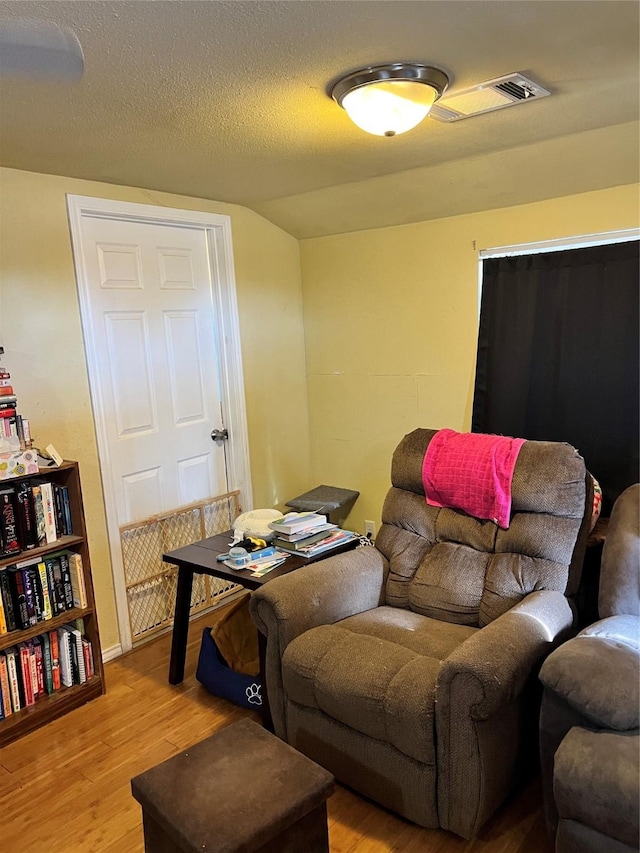 living room with light hardwood / wood-style flooring and a textured ceiling