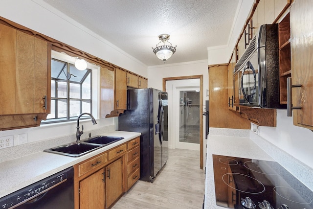 kitchen with sink, a textured ceiling, ornamental molding, light hardwood / wood-style floors, and black appliances