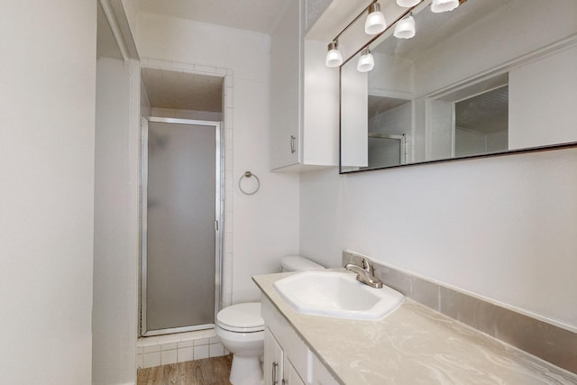 bathroom featuring hardwood / wood-style flooring, vanity, toilet, and a shower with shower door