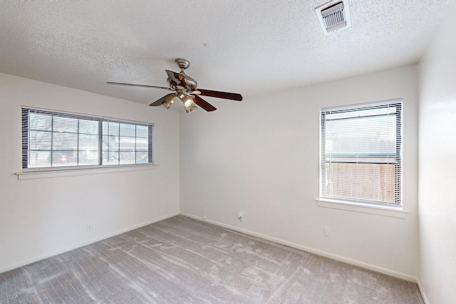 carpeted empty room with a textured ceiling and ceiling fan