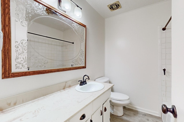 bathroom with vanity, hardwood / wood-style floors, walk in shower, and toilet