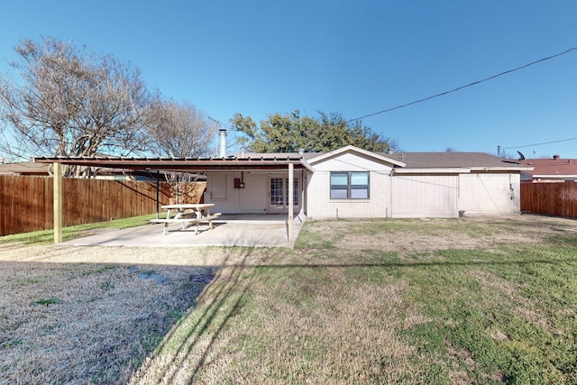 rear view of property with a yard and a patio area