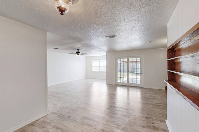 unfurnished room featuring ceiling fan, a textured ceiling, and light wood-type flooring