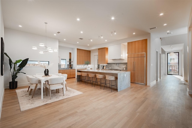 kitchen featuring a breakfast bar, paneled fridge, visible vents, and modern cabinets