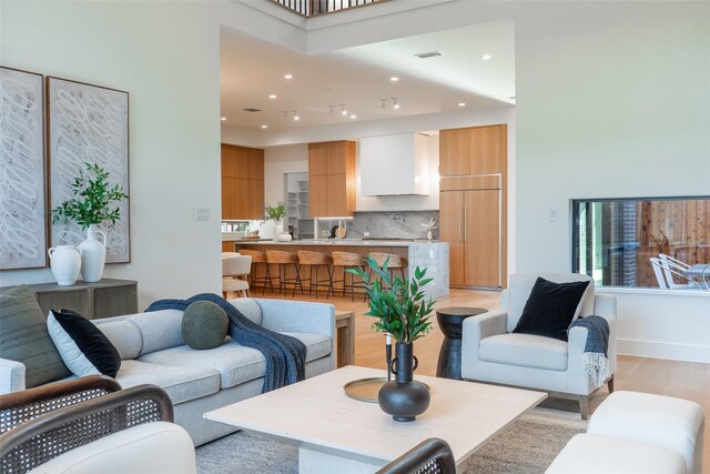 living room featuring built in shelves, a high end fireplace, and a high ceiling