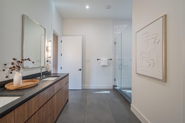 bathroom with baseboards, visible vents, tile patterned floors, a shower stall, and a sink