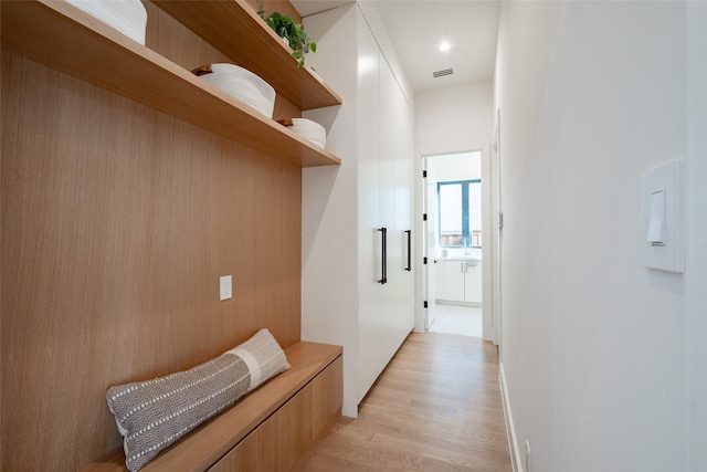 hallway with light wood finished floors and visible vents