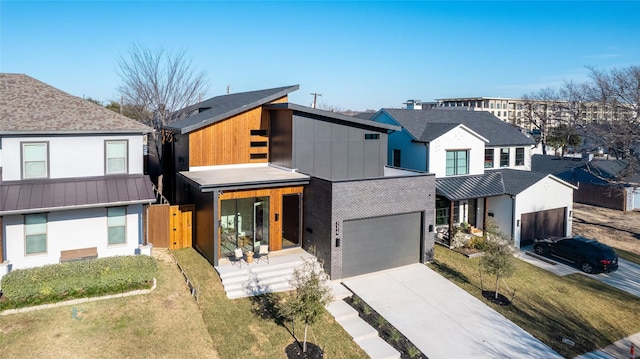 view of front of property featuring a porch, a standing seam roof, metal roof, and driveway