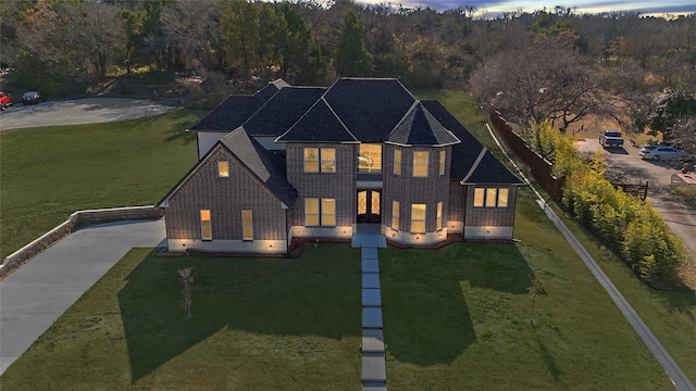 back house at dusk with a lawn