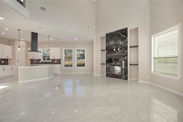 unfurnished living room with a high ceiling and a fireplace