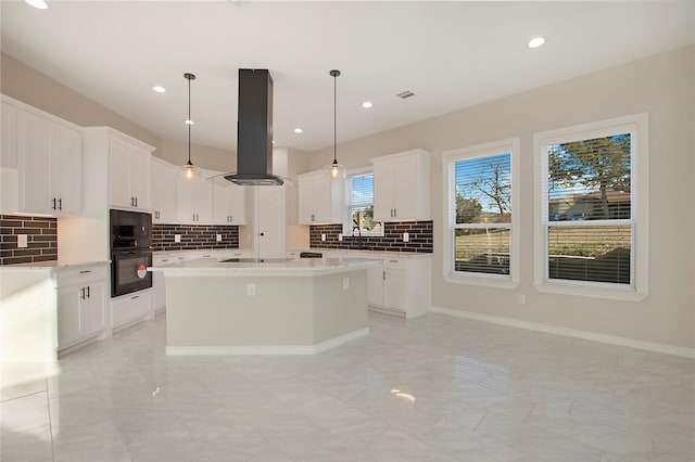 kitchen with a kitchen island, pendant lighting, island range hood, white cabinetry, and black appliances