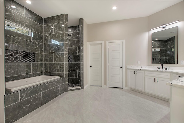 bathroom with vanity and shower with separate bathtub