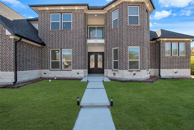 rear view of property with french doors and a yard