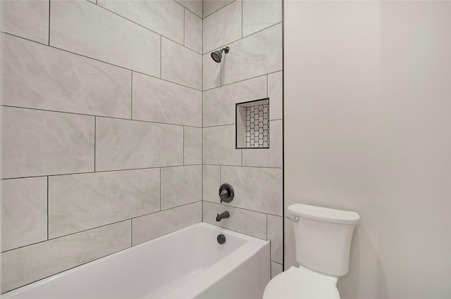 bathroom with toilet and tiled shower / bath combo