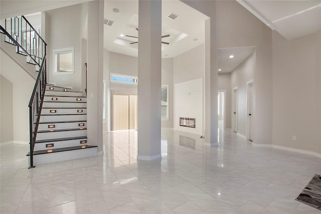 stairway featuring ceiling fan and a high ceiling