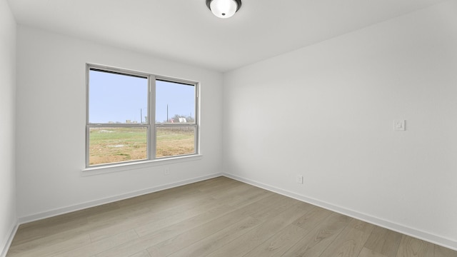 empty room with light wood-style floors and baseboards