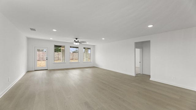 unfurnished room with baseboards, light wood finished floors, visible vents, and recessed lighting