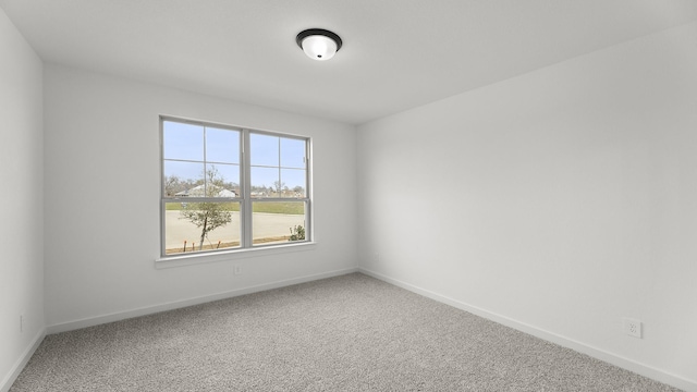 unfurnished room with carpet and baseboards