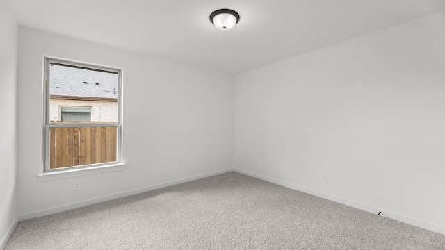 carpeted empty room featuring baseboards