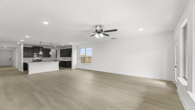 unfurnished living room featuring light wood finished floors, recessed lighting, visible vents, ceiling fan, and baseboards