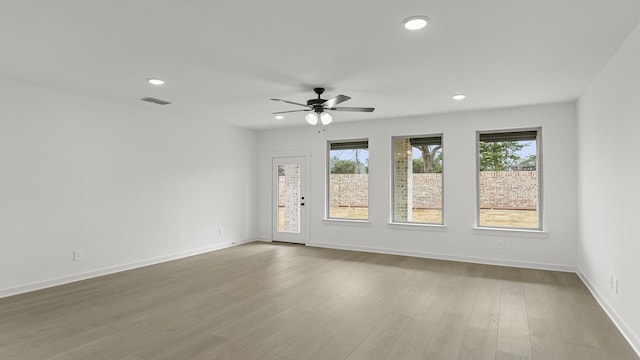 unfurnished room featuring baseboards, wood finished floors, visible vents, and recessed lighting