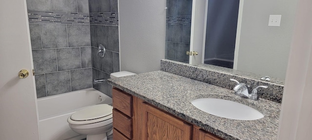 full bathroom featuring tiled shower / bath combo, vanity, and toilet