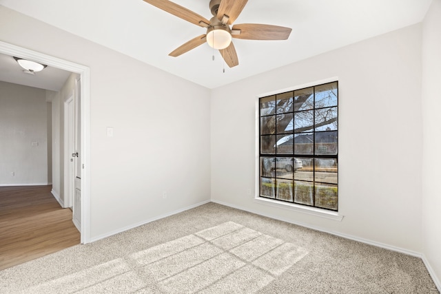 carpeted spare room featuring ceiling fan