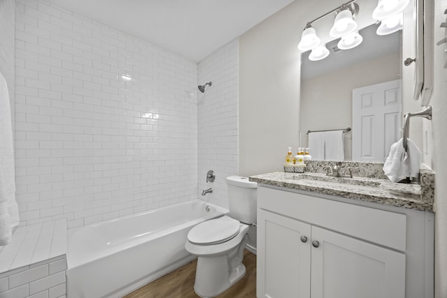 full bathroom featuring tiled shower / bath, vanity, toilet, and hardwood / wood-style floors