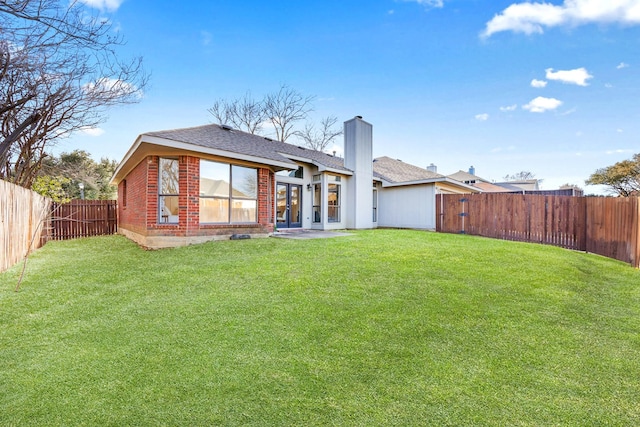 rear view of house featuring a lawn