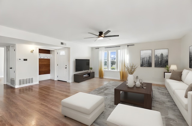 living room featuring wood-type flooring and ceiling fan