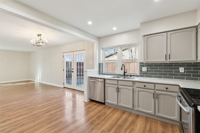 kitchen featuring sink, gray cabinetry, stainless steel appliances, tasteful backsplash, and light hardwood / wood-style floors