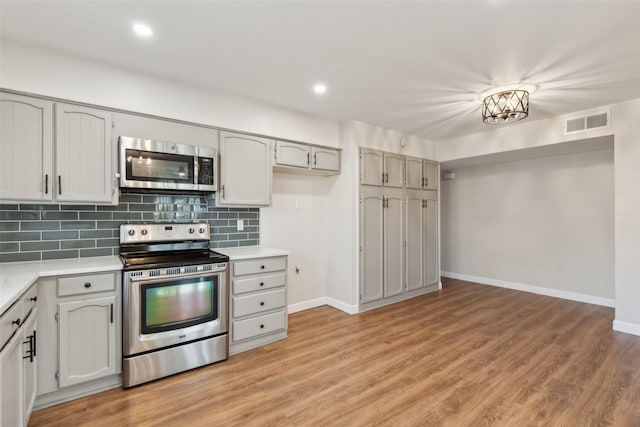 kitchen featuring backsplash, light hardwood / wood-style flooring, and stainless steel appliances