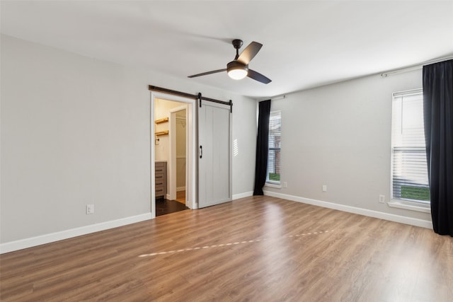 spare room with plenty of natural light, a barn door, and light hardwood / wood-style floors