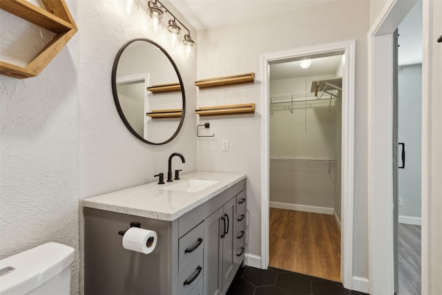 bathroom featuring tile patterned floors, vanity, and toilet