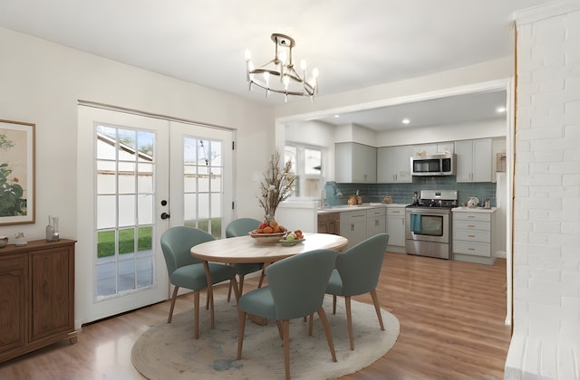 dining room featuring french doors, a chandelier, and light hardwood / wood-style flooring