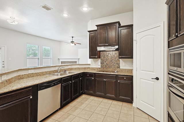 kitchen featuring appliances with stainless steel finishes, sink, backsplash, light tile patterned floors, and kitchen peninsula