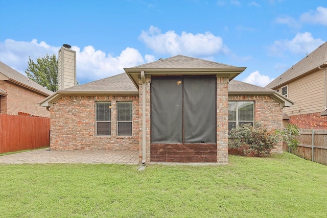 rear view of property featuring a patio and a lawn