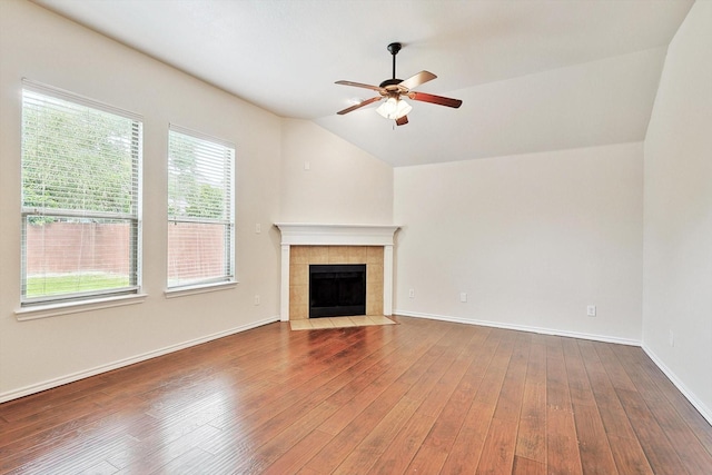 unfurnished living room featuring hardwood / wood-style flooring, a tile fireplace, lofted ceiling, and ceiling fan