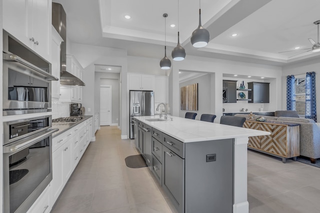 kitchen with a spacious island, a raised ceiling, and white cabinets