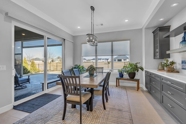 tiled dining room featuring crown molding